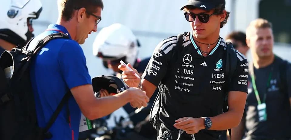 Driver signing autographs in paddock area