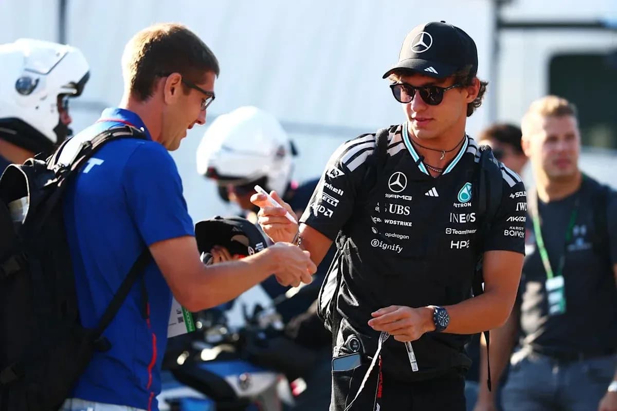Driver signing autographs in paddock area