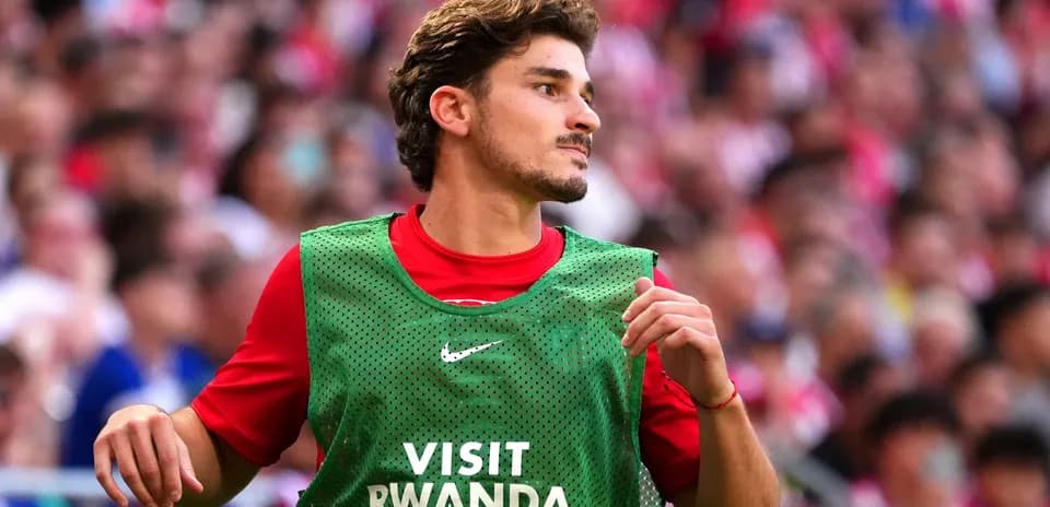 Player in green training bib on sidelines