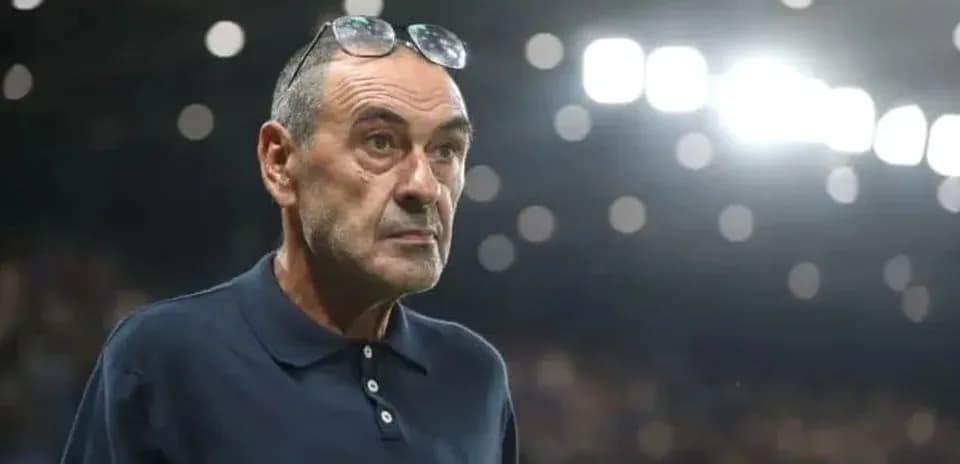 Coach observing match from sidelines with glasses