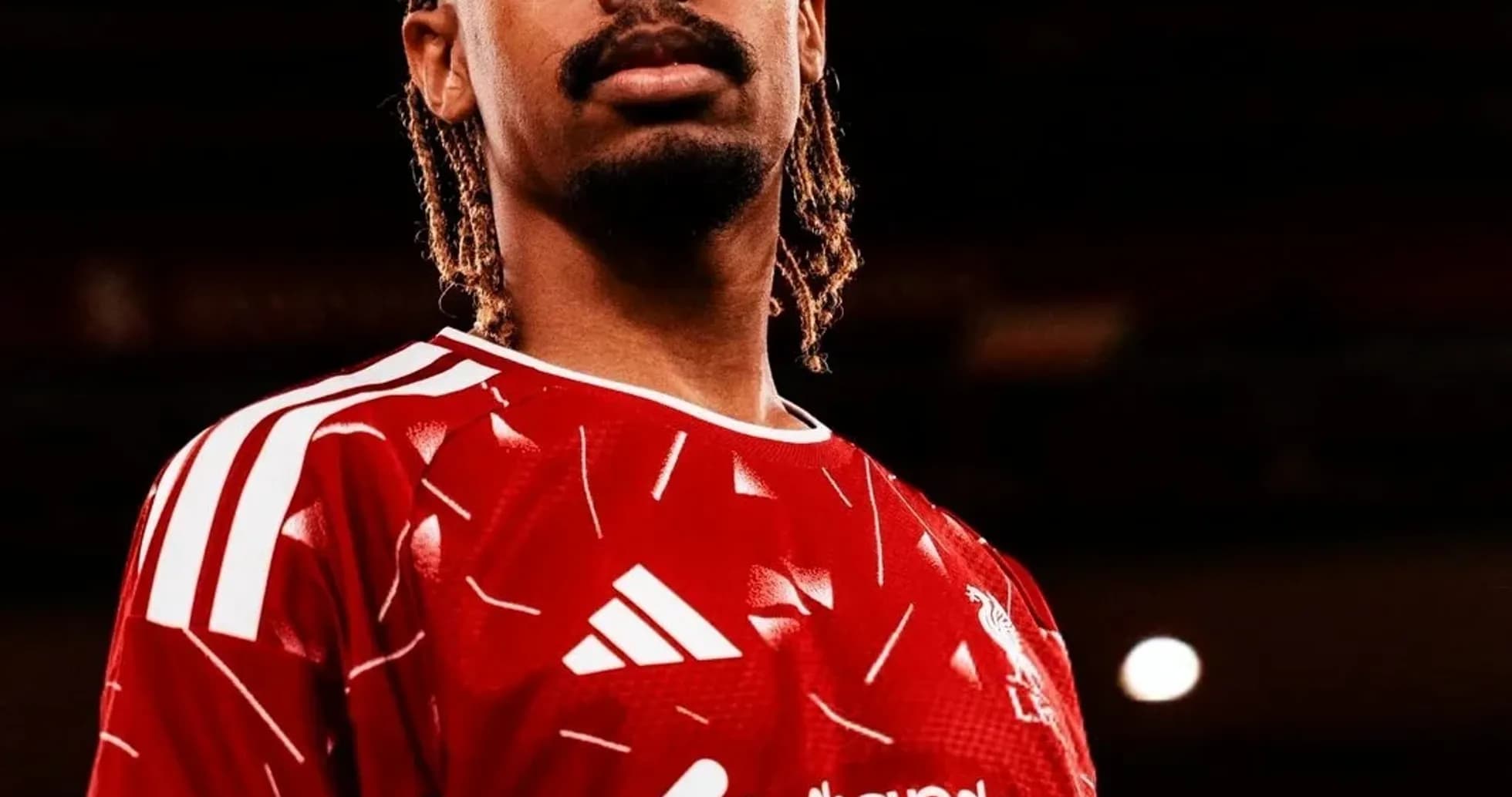 Player posing in Liverpool's red home jersey