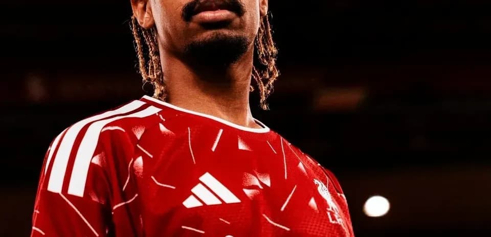 Player posing in Liverpool's red home jersey