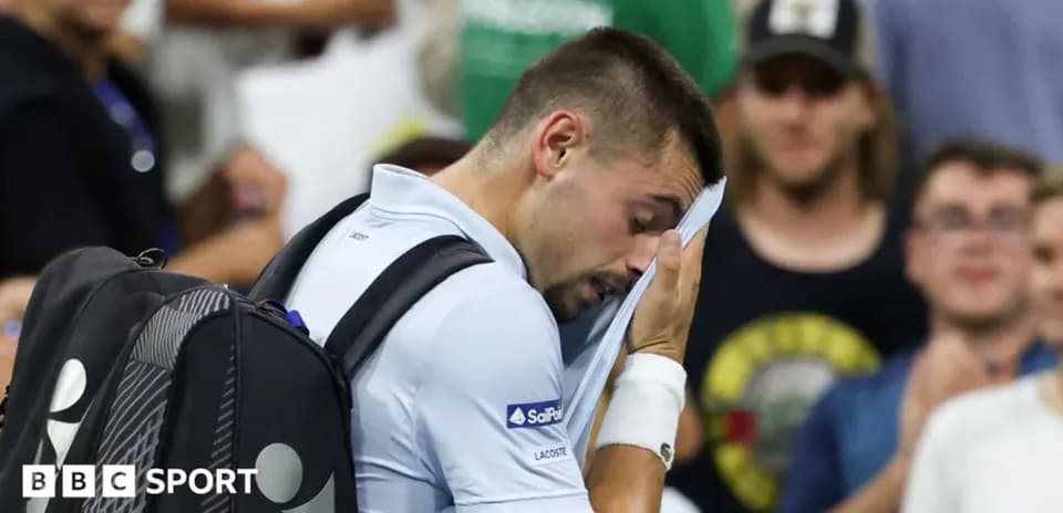 Player wiping sweat during tennis match