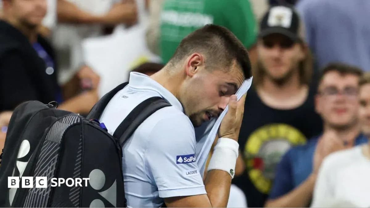 Player wiping sweat during tennis match