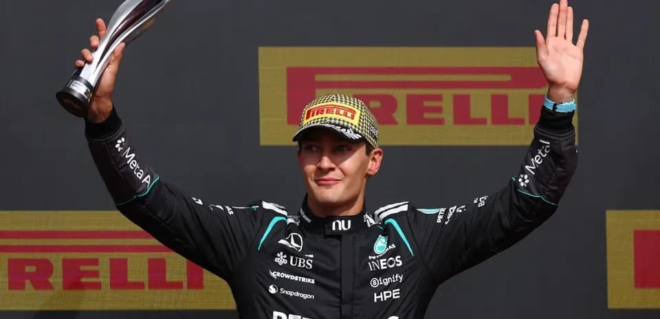 Driver celebrating with trophy on podium after race