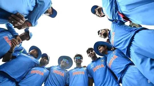 Indian cricket team huddled in blue uniforms