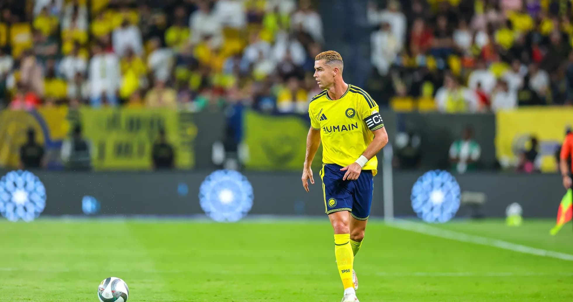 Player in yellow kit with captain's armband on field