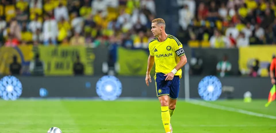 Player in yellow kit with captain's armband on field