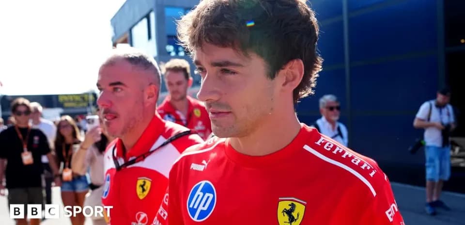 Two Ferrari team members walking in paddock area
