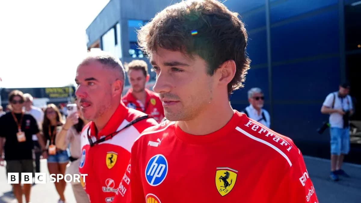 Two Ferrari team members walking in paddock area