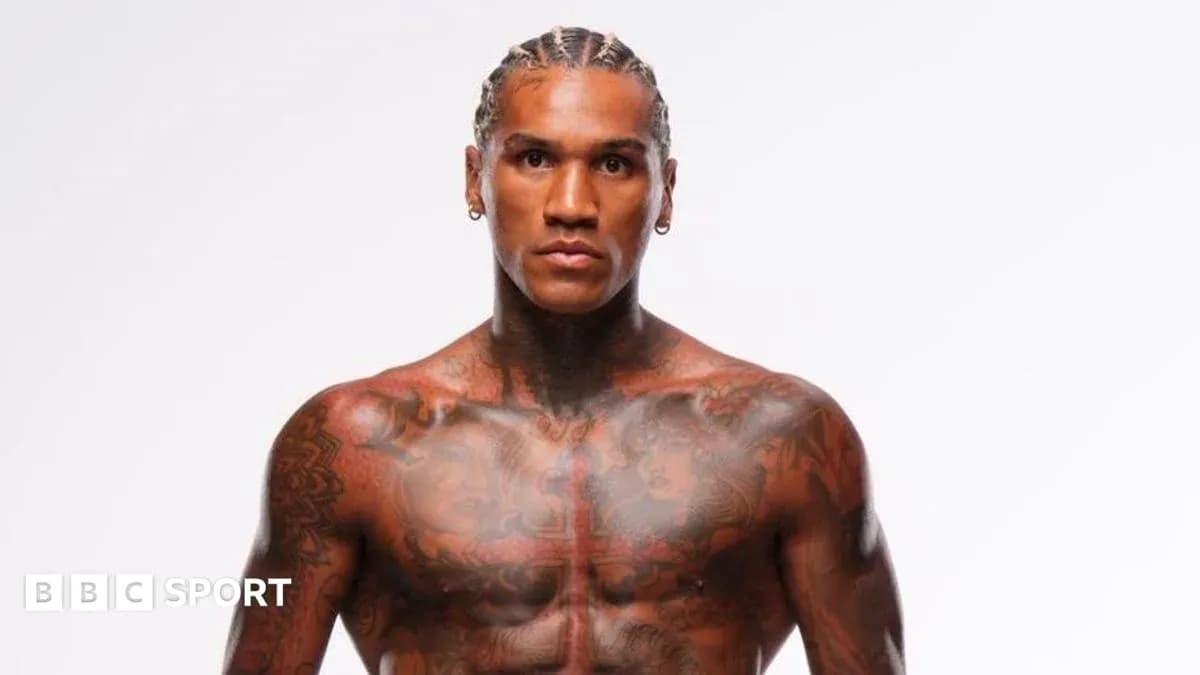 Muscular athlete with tattoos posing against white background