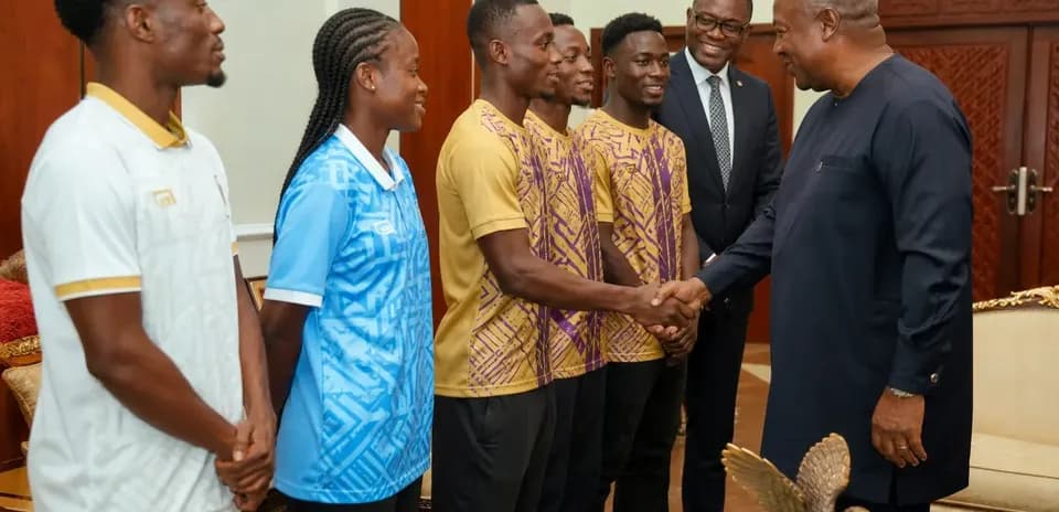 Athletes shaking hands with dignitaries in meeting