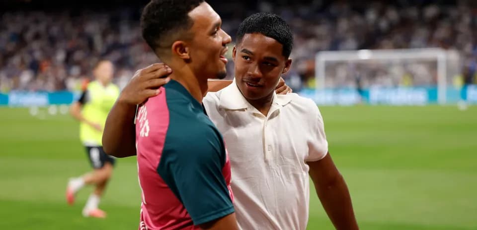 Two young men interacting on a football pitch