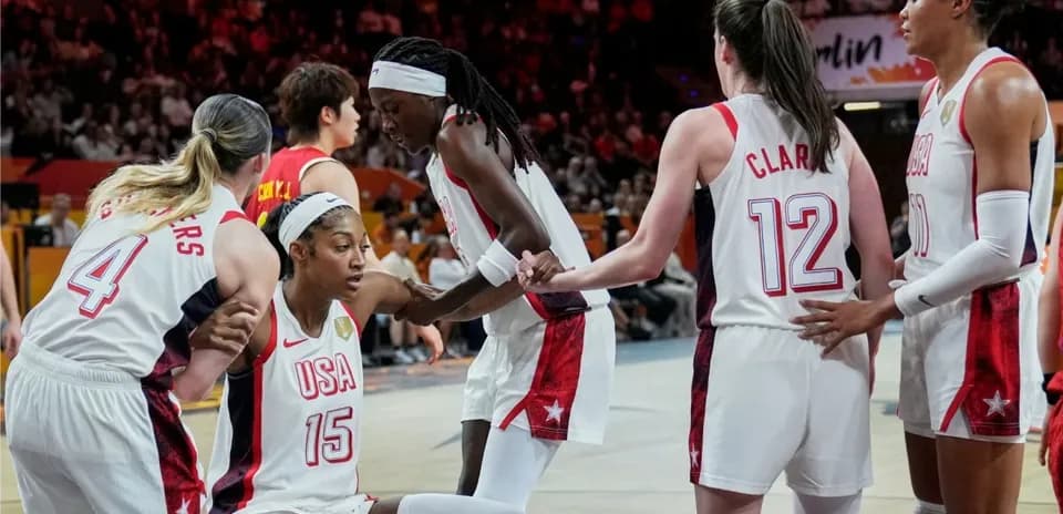 USA players assisting teammate during basketball game