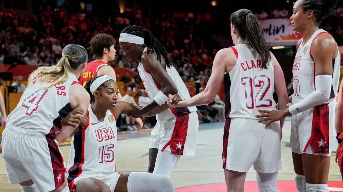 USA players assisting teammate during basketball game USA players assisting teammate during basketball game