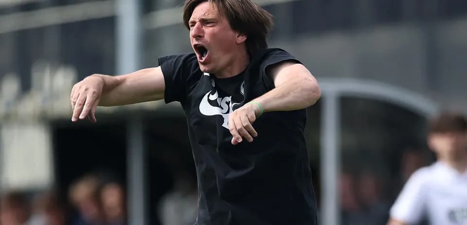 Coach gesturing passionately during a match