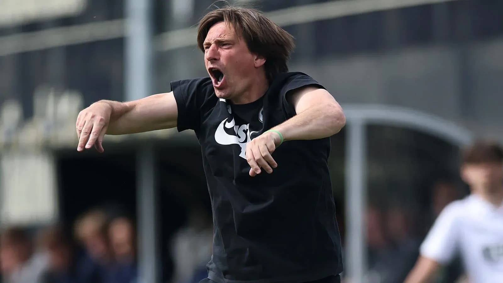 Coach gesturing passionately during a match