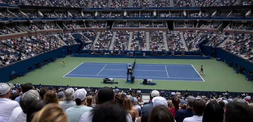 Tennis match in a crowded stadium with players