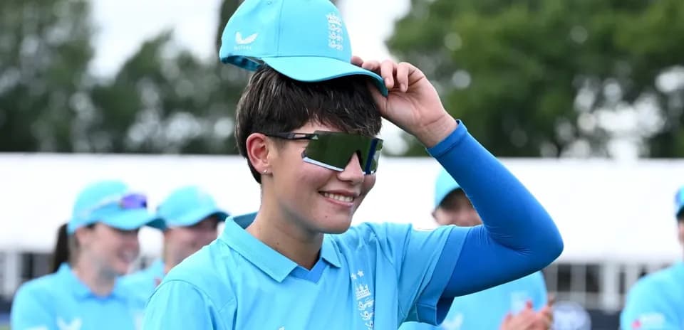 Cricketer adjusting cap during team event