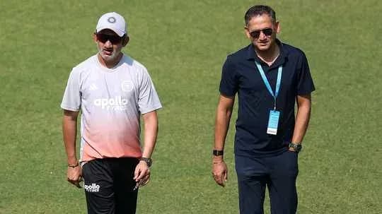Two coaches walking on the cricket field