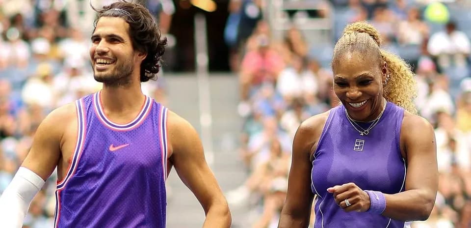 Two tennis players smiling during a match