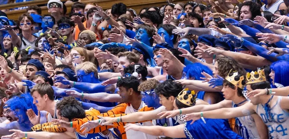Duke fans cheering with blue body paint in stadium