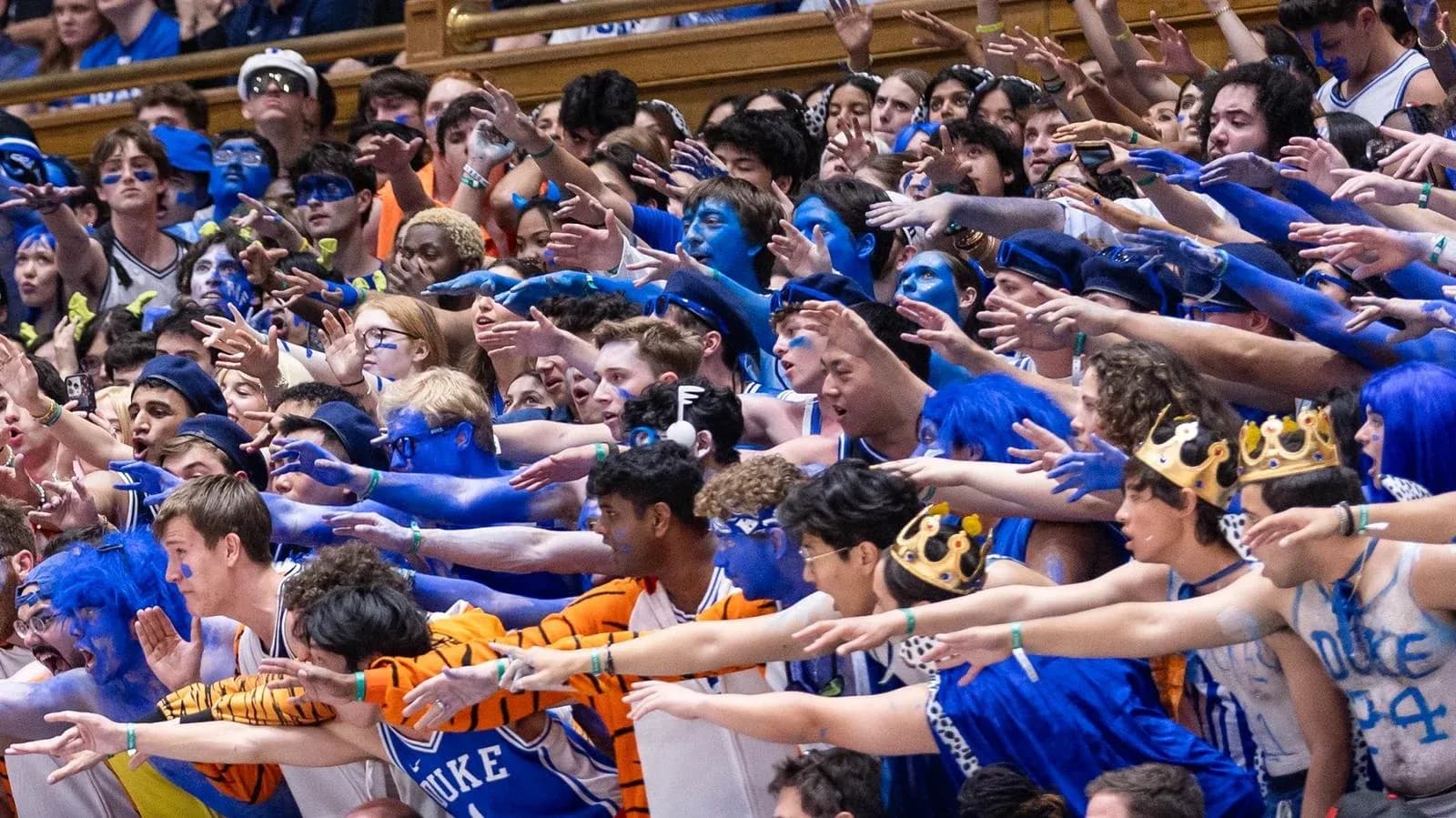 Duke fans cheering with blue body paint in stadium