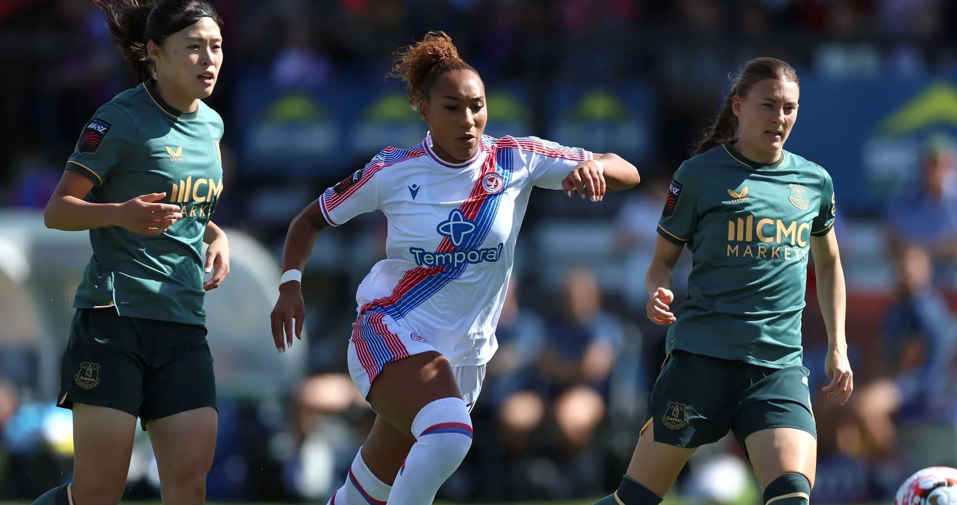 Three female players competing for the ball during match