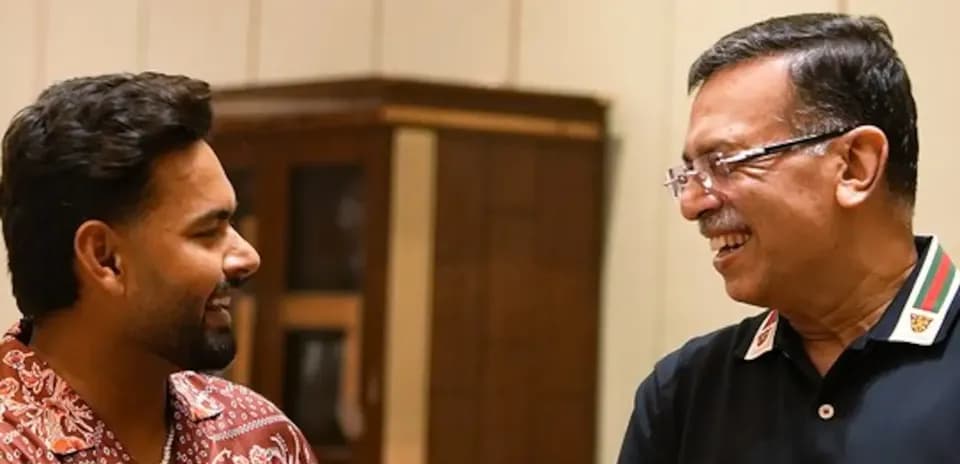 Two men smiling and conversing indoors