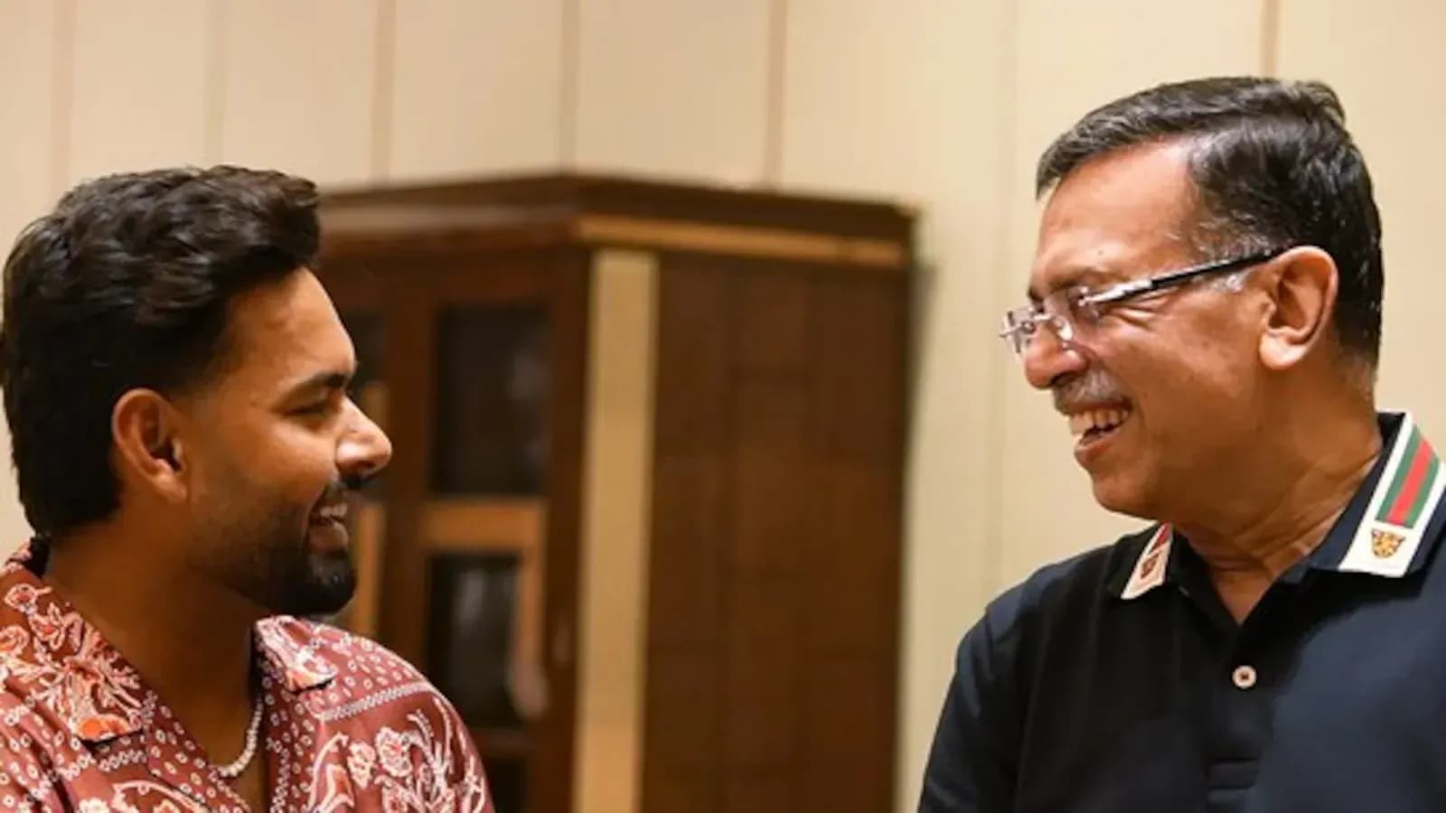 Two men smiling and conversing indoors Two men smiling and conversing indoors