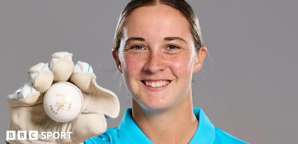 Athlete holding a cricket ball and smiling