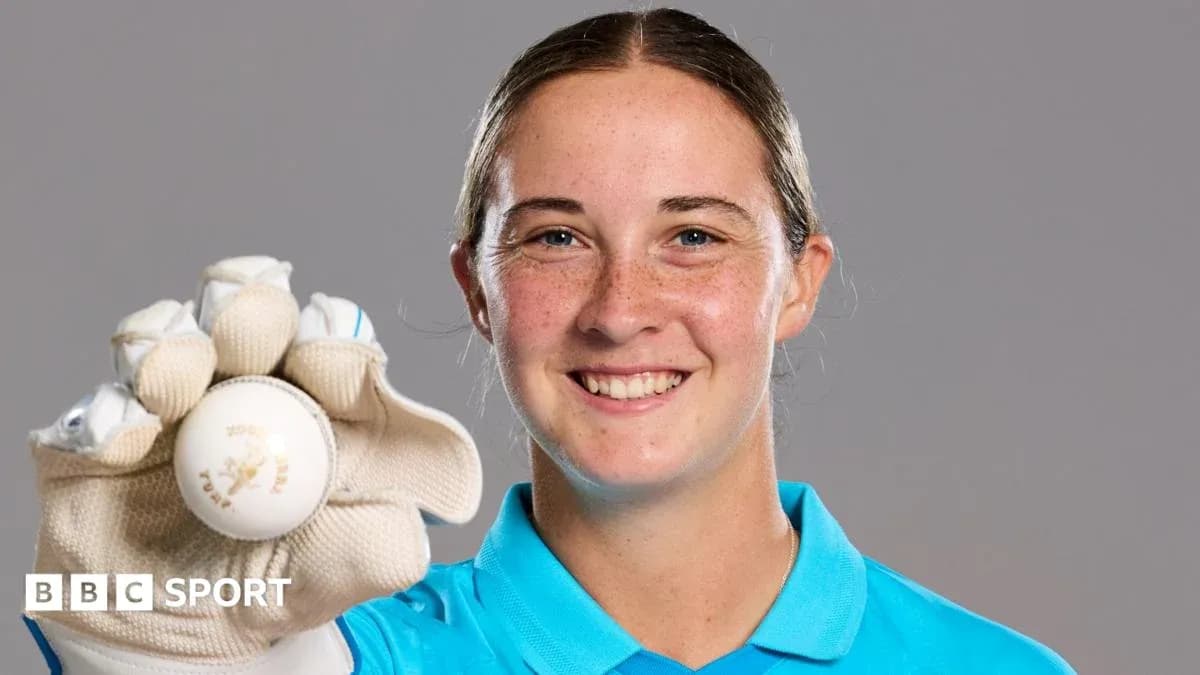 Athlete holding a cricket ball and smiling