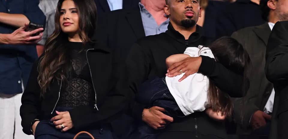 Couple watching event with child in arms