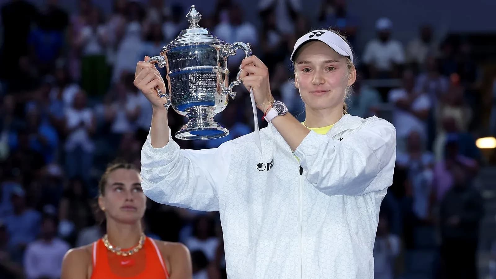 Player holding trophy with opponent in background