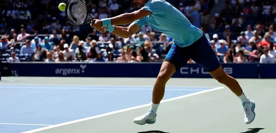 Player lunging to hit a tennis ball during match