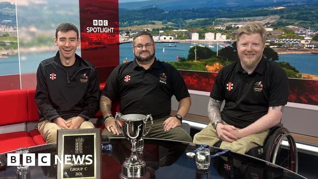 Three men sitting with trophy on news set