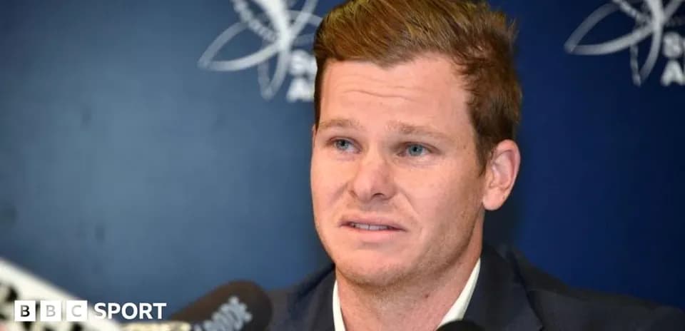 Cricketer speaking at press conference with microphones