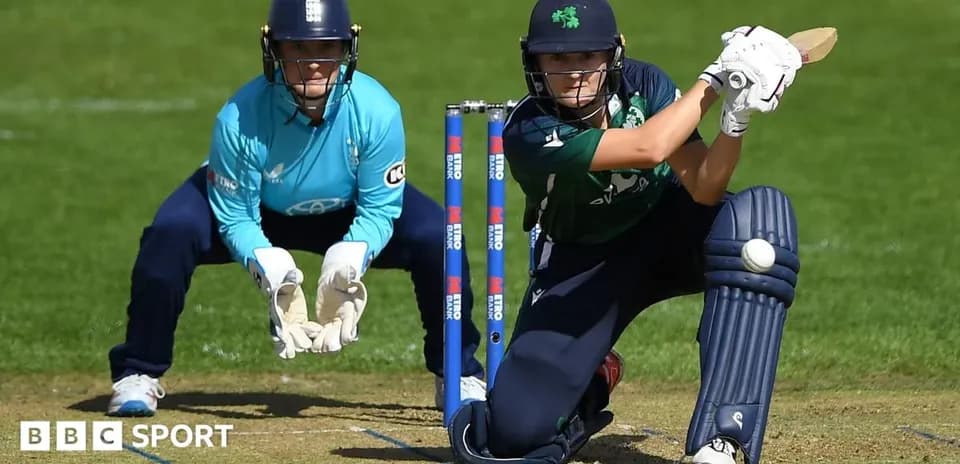 Batter playing a shot with wicketkeeper behind