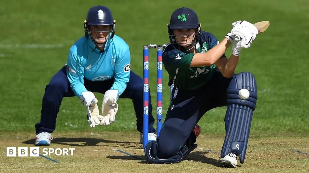 Batter playing a shot with wicketkeeper behind