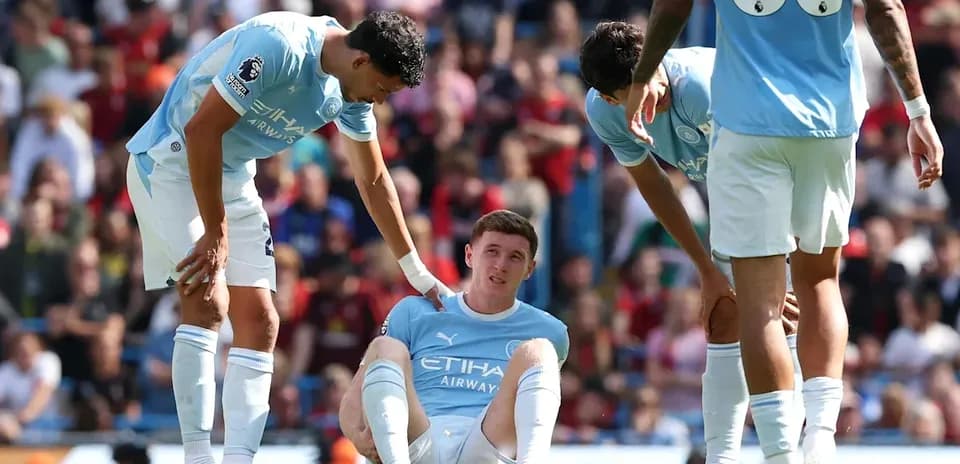 Player sitting on the ground, teammates offering support