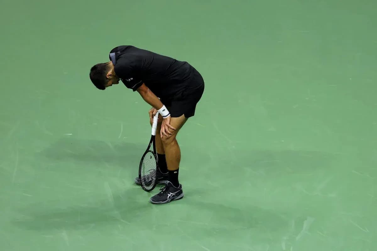Tennis player bending over on the court