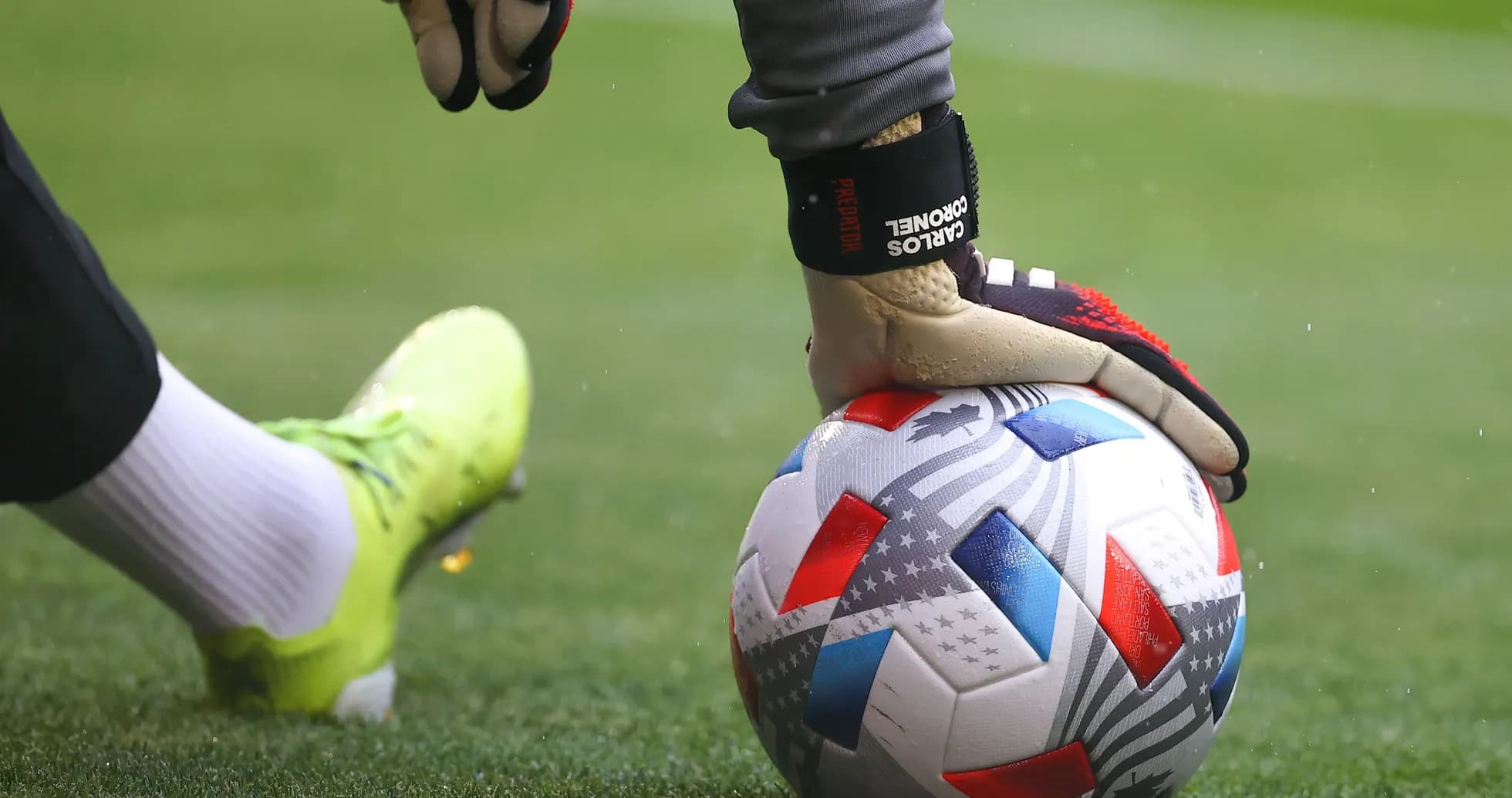 Goalkeeper placing hand on soccer ball before kick