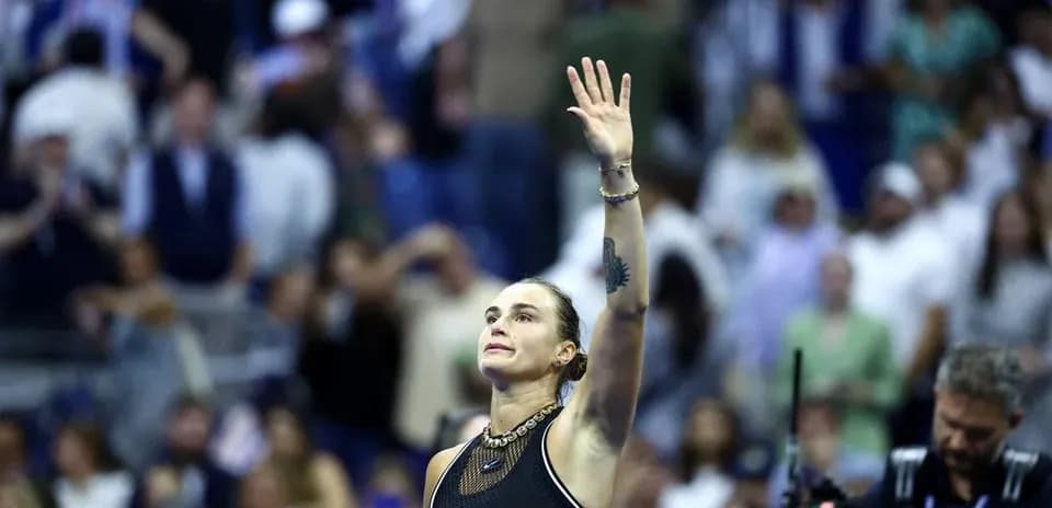 Tennis player waving to the crowd after match