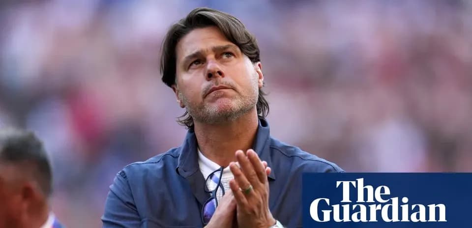 Coach with hands clasped, looking upward in stadium