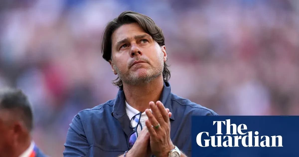 Coach with hands clasped, looking upward in stadium