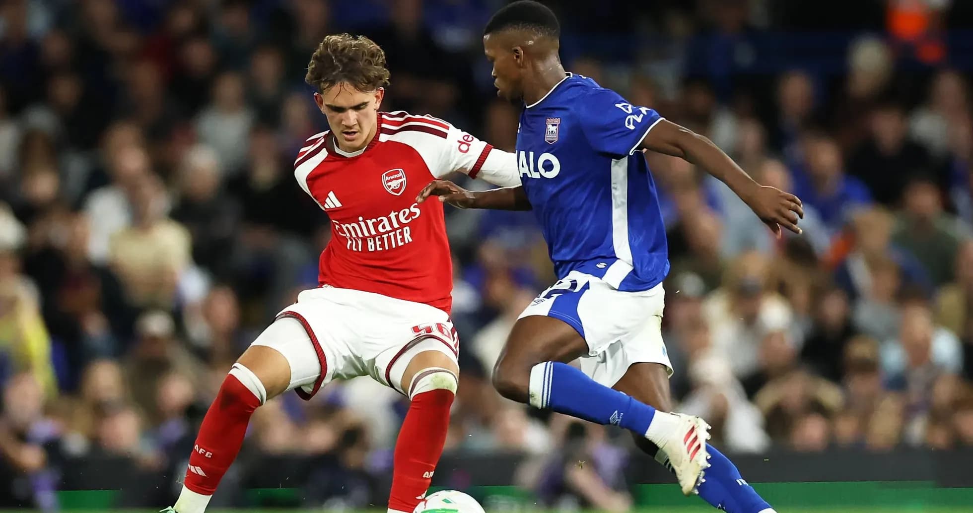 Player in red and player in blue contesting for ball