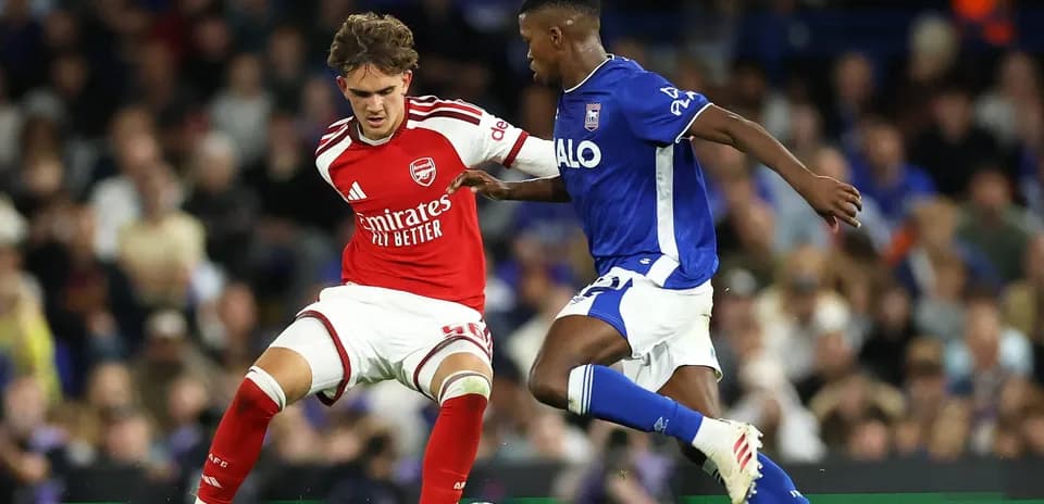 Player in red and player in blue contesting for ball
