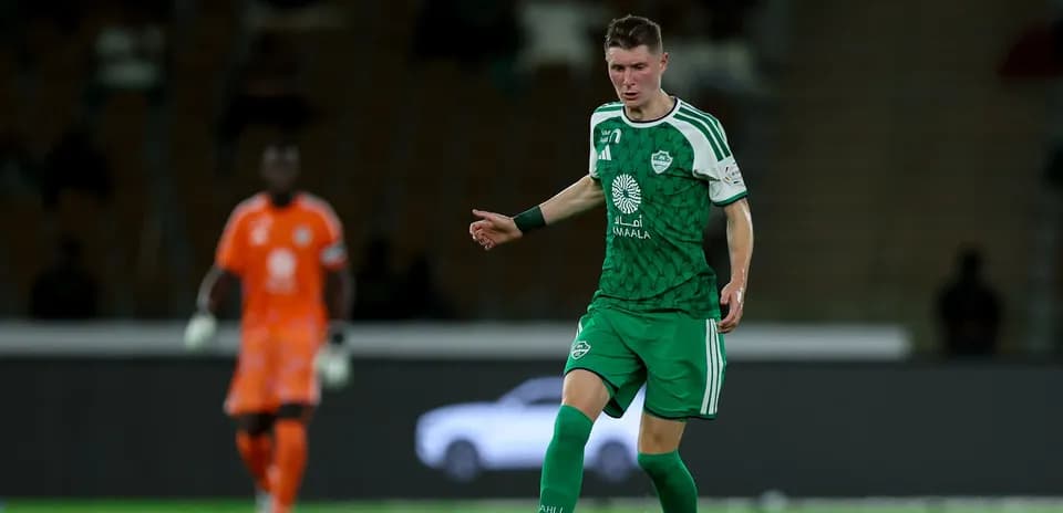 Player in green kit controlling the ball on field