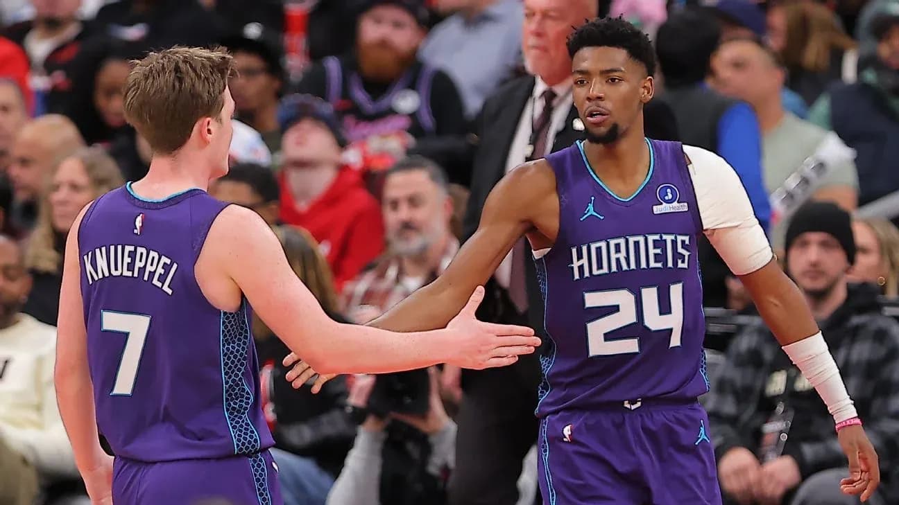Two Hornets players exchanging a handshake during game
