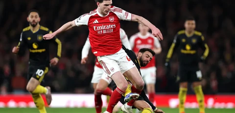 Arsenal player being tackled during a match